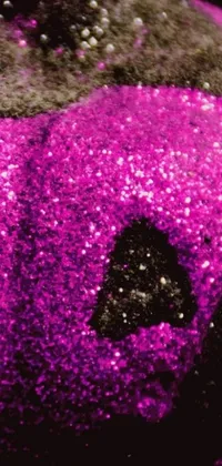 This phone live wallpaper showcases a dazzling purple glitter pumpkin resting on a table