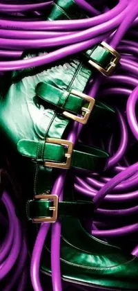 This vibrant and bold phone live wallpaper features a pair of electric green shoes resting on top of a pile of tangled purple cords, complete with shimmering gold cable accents