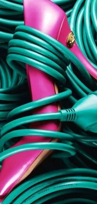 Introducing a stunning phone live wallpaper featuring a pair of chic pink shoes resting on top of a harmonious stack of green hoses