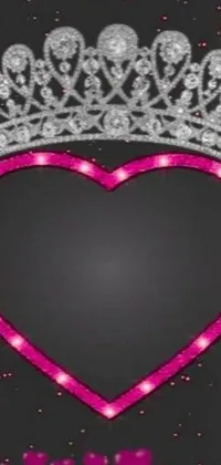 This exquisite phone live wallpaper showcases a gorgeous pink heart with a majestic crown on top, against a black backdrop
