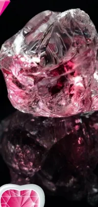 This vibrant live phone wallpaper features a beautiful pink diamond resting atop a sleek black surface, surrounded by a stunning glass antikythera