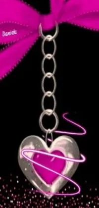 This live phone wallpaper features a heart-shaped keychain with a pink ribbon, set against an airbrushed graffiti-inspired background