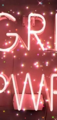 This phone live wallpaper features a neon sign with the words "girl power", a brightly colored album cover, and whimsical elements such as war paint, fairy dust, and party lights