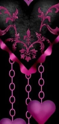 This live phone wallpaper is a beautiful representation of gothic art, featuring a dark black heart adorned with dangling pink hearts, delicately surrounded by damask patterns