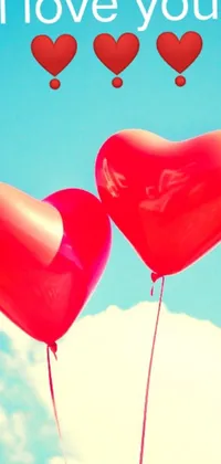 This phone live wallpaper showcases two heart-shaped balloons with the phrase "i love you" set against a vivid blue sky