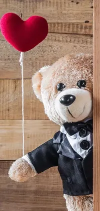 This charming phone live wallpaper showcases a cute teddy bear in a tuxedo holding a red heart-shaped balloon