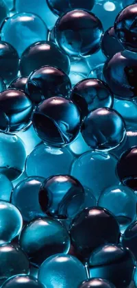 Experience the mesmerizing beauty of a phone live wallpaper featuring a collection of glass balls on a table