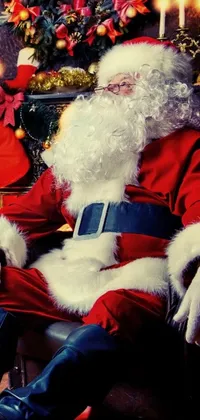 This stunning phone live wallpaper depicts Santa Claus sitting in a chair in front of a beautiful Christmas tree