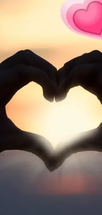 If you're looking for a heartwarming live wallpaper for your phone, look no further! This wallpaper features a beautiful, backlit picture of someone making a heart shape with their hands
