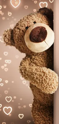 This live wallpaper for phones features a delightful teddy bear leaning against a wall with heart designs in the background