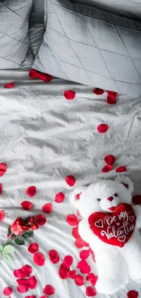 Looking for a live wallpaper to add some romance to your phone? Check out this white teddy bear live wallpaper! With a cozy flatlay design by Valentine Hugo, the wallpaper features a cute teddy bear sitting on a bed surrounded by red hearts, rose petals, and pink blankets and pillows