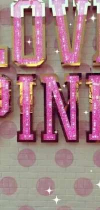 This phone wallpaper boasts a bold "Love Pink" sign adorning the side of a building