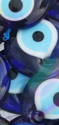 This mobile live wallpaper showcases a pile of blue and white evil eyes in the style of hurufiyya