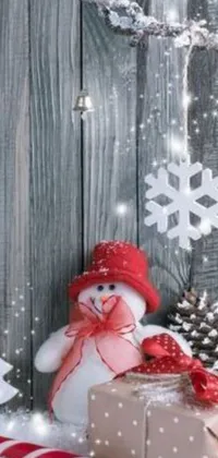 This phone live wallpaper showcases a delightful snowman resting on a wintery ground covered with snow