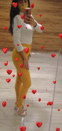 This live phone wallpaper features a woman taking a mirror selfie in yellow leggings and top