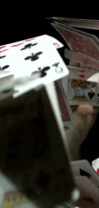 This live wallpaper portrays a person holding a deck of cards in their hands while balancing a box filled with additional cards on their head