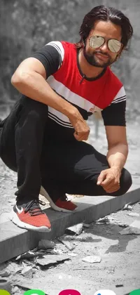 This phone live wallpaper features a black and white photograph of a skateboarder in a red shirt and brown pants, wearing Adidas clothing and posed in an eye-level view while riding down a street