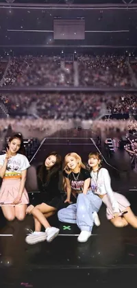 This phone live wallpaper showcases a captivating image of girls sitting on a stage, ideal for music and art enthusiasts
