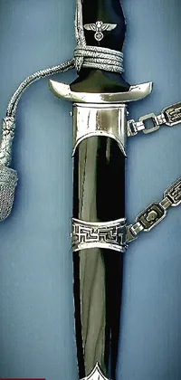 This phone live wallpaper showcases a digital rendering of a knife with a chain on it, designed using hurufiyya artistic techniques