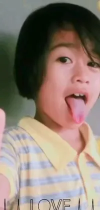 This live wallpaper features a playful anime-style design of a young boy making a heart sign with his tongue