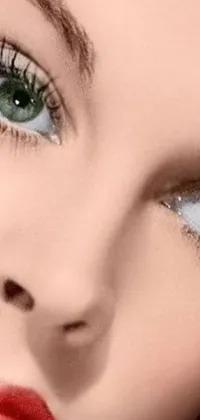 This phone live wallpaper features a close-up of a doll's face with green and silver eyes and wispy blonde hair