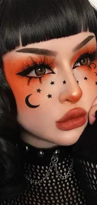 This phone live wallpaper showcases a striking woman with crescents and stars painted on her face