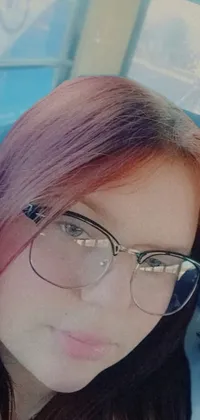 This phone live wallpaper showcases a captivating close-up image of a person wearing glasses on a bus with dark red hair