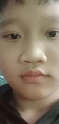 This charming phone live wallpaper reveals a child's close-up portrait as they wear a scarf
