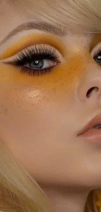 This vibrant live wallpaper highlights a woman donning a yellow hat, with a close-up shot of her face and intricate eye makeup inspired by 90s trends