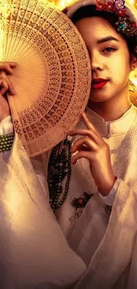 This live wallpaper for your phone showcases a Vietnamese woman holding a fan in front of her face, set against a beautiful historical backdrop