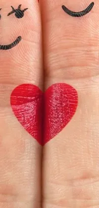 This stunning phone live wallpaper depicts a pair of hyperrealistic fingers painted with smiley faces and red lips, forming a heart shape