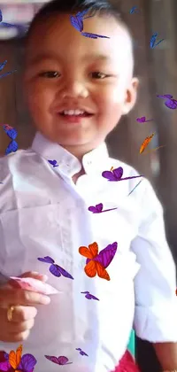 This live wallpaper features a joyful young boy in a white shirt and red shorts holding a phone with colorful apps and icons floating around him