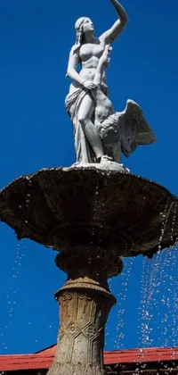 This phone live wallpaper features a stunning fountain with a unique statue in the figuration libre style atop it, situated in Armenia Quindio