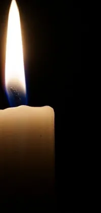 This phone live wallpaper showcases a simple yet ubiquitous image of a lit candle against a black background