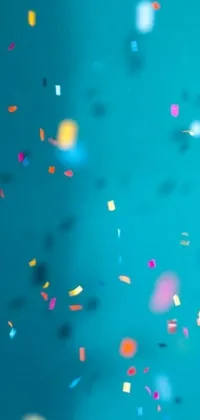 This dynamic phone live wallpaper features a stunning display of confetti sprinkles on a bold blue backdrop