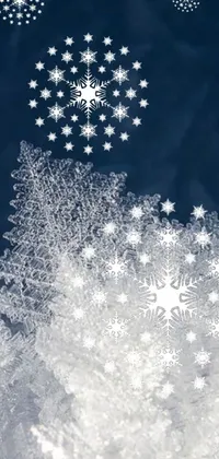 This live wallpaper features a winter wonderland with intricate snowflakes atop a snowy landscape
