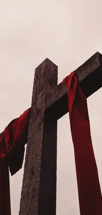 Looking for a stunning live wallpaper for your phone? Check out this beautiful design featuring a cross with a red ribbon tied to it