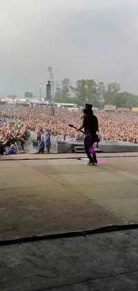 Looking for the ultimate rock concert experience on your phone? This live wallpaper puts you right in the middle of the action with a man playing guitar on stage in front of an excited crowd