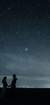This phone live wallpaper showcases a serene image of a couple standing together under a beautiful night sky full of sparkling stars