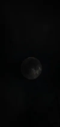 The phone live wallpaper depicts a mesmerizing full moon in a dark and overcast sky during an eclipse