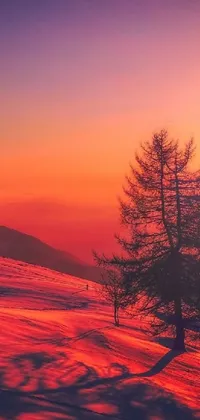 Adorn your phone screen with this breathtaking live wallpaper that showcases a snowy slope, mountain range, and a pair of trees