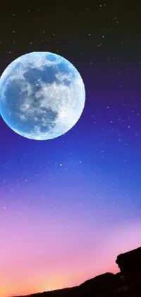 This phone live wallpaper features a stunning hilltop view under a full moon with a mix of blue and pink colors