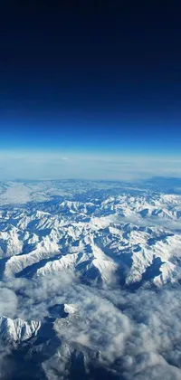 This live wallpaper showcases snow-capped mountains seen from an airplane, providing a view of the breathtaking natural beauty of the world