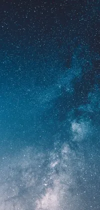 This stunning live wallpaper depicts two individuals standing atop a snow-covered slope gazing up at the breathtaking Milky Way galaxy