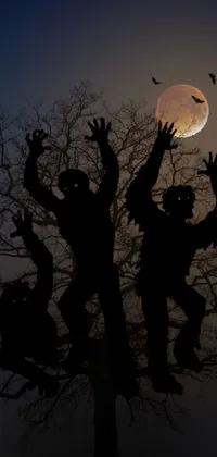 This phone live wallpaper depicts a group of people standing in front of a tree on a spooky Halloween night