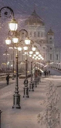 This live phone wallpaper showcases a row of street lamps on a snow-covered sidewalk, set against a stunning city skyline