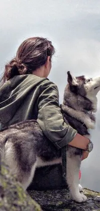 If you're on the hunt for a captivating live wallpaper for your phone, look no further than this enchanting image featuring a strong and fearless woman and her loyal husky dog