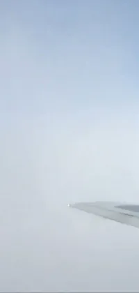 This phone live wallpaper features an airplane wing flying through fog