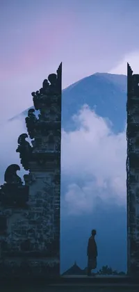 The phone live wallpaper displays an extraordinary scene featuring a monumental gate in front of a mountain range