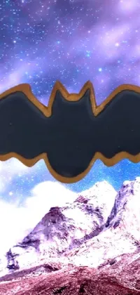 This phone live wallpaper showcases a stunning image of a bat in flight against a mountainous landscape